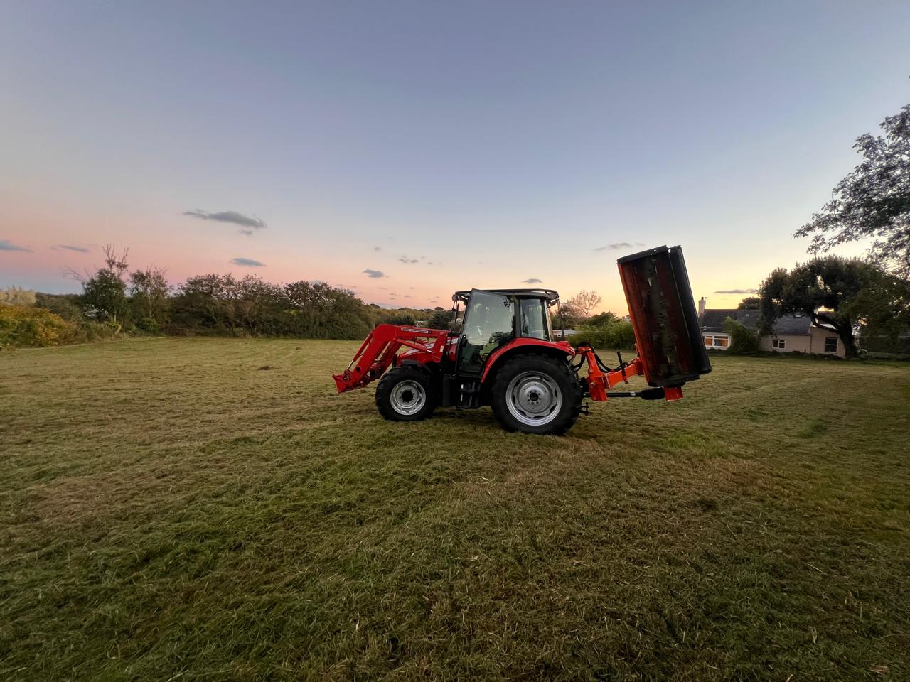 Stonebridge & Sons tractor with topper attachment in a field at sunset